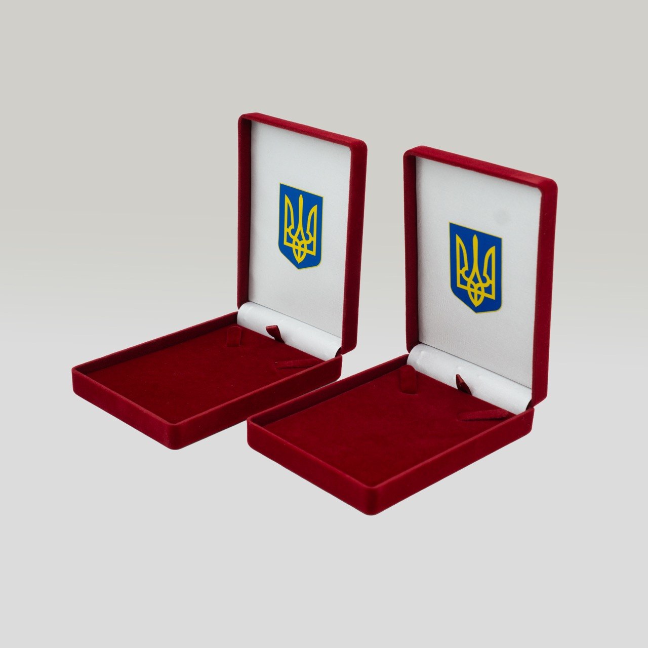 Два відкриті оксамитові футляри з тризубом на кришці